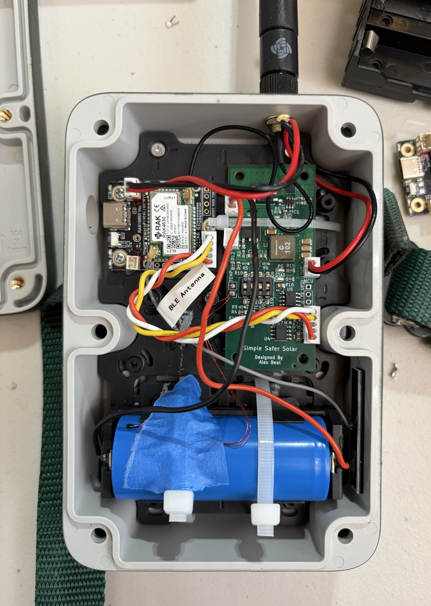 A LiFePV Power Module prototype wired into a weatherproof enclosure alongside a RAK4630 LoRa board, battery, and antenna for field testing.